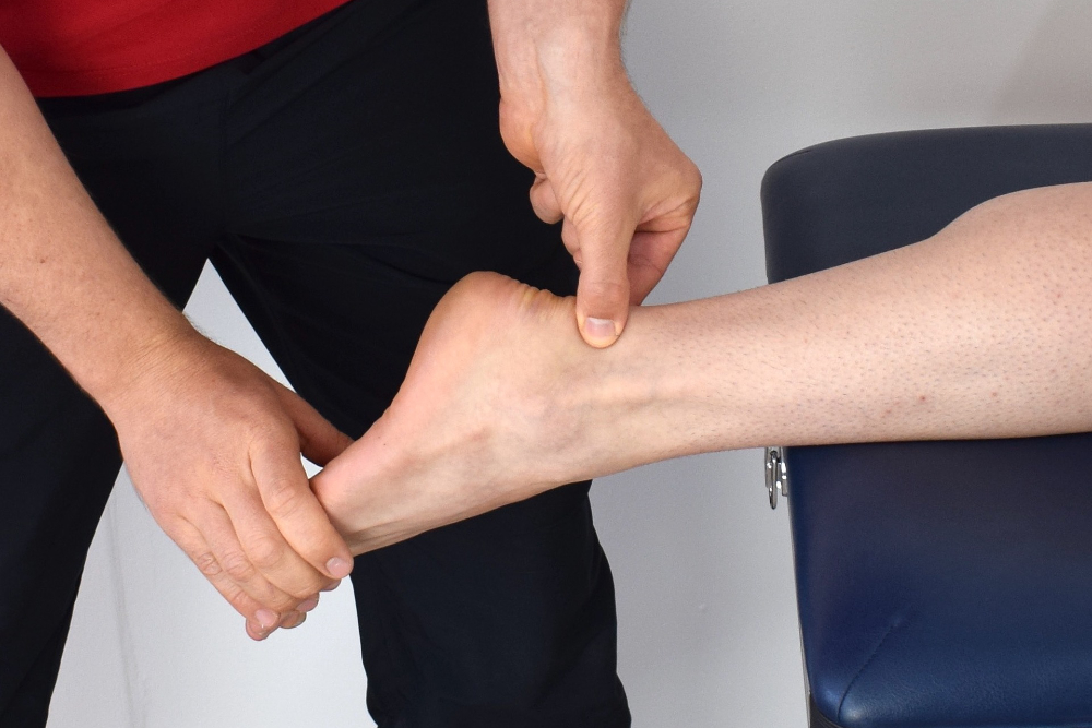 Physical therapist stretches patient's ankle