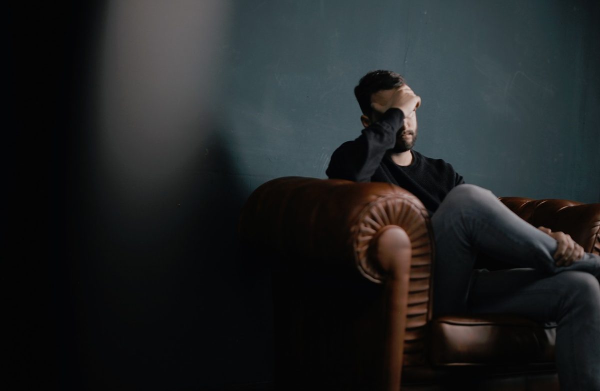 Man sitting in leather chair with headache
