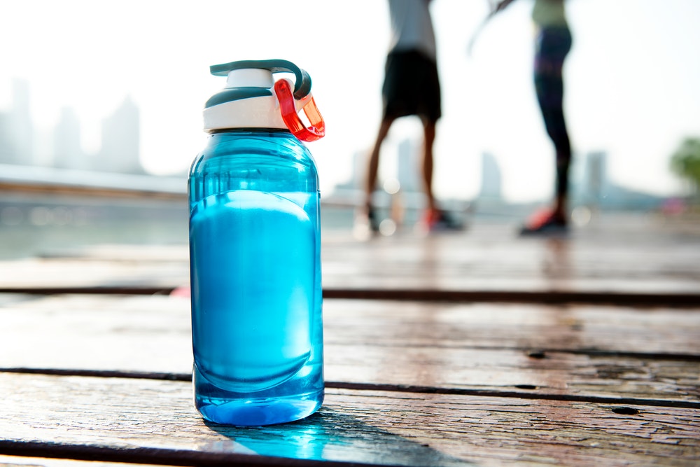 Blue reusable water bottle on a wooden boardwalk