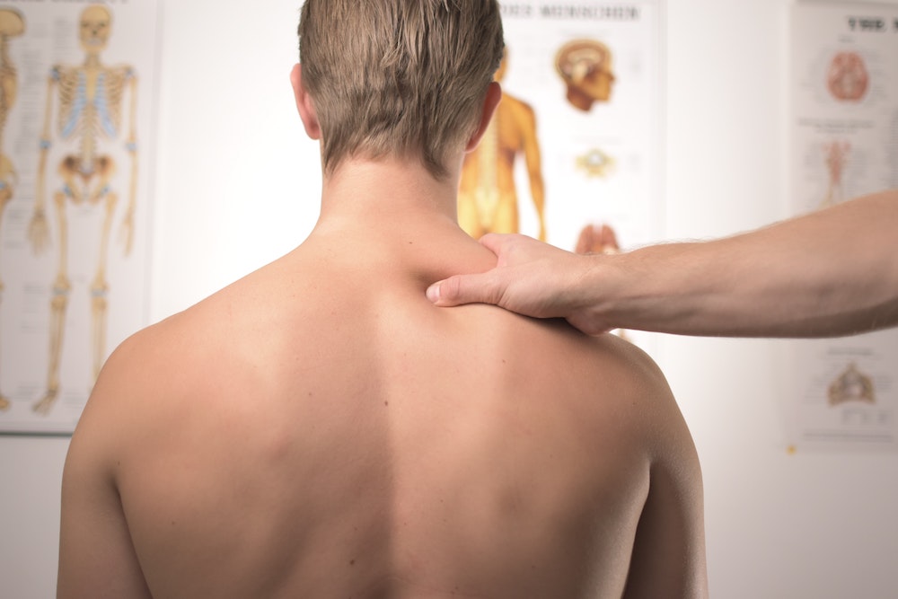 Man receiving neck and shoulder treatment at physical therapist